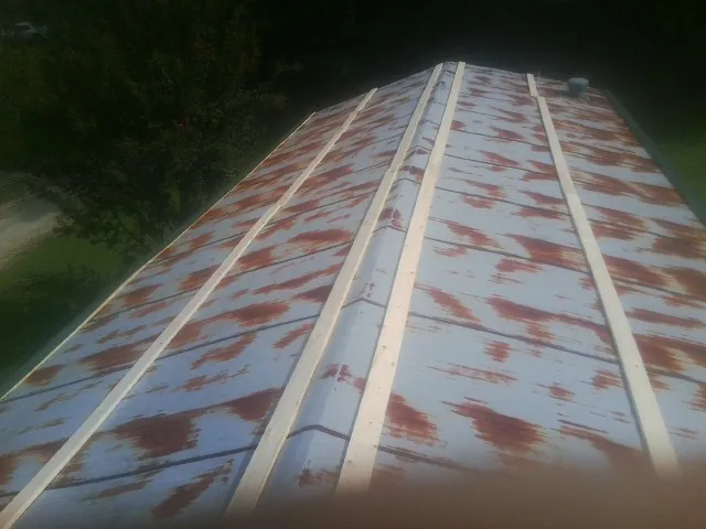 Rusted metal roof panels with new wood purlins before replacement — Storm Damage Roof Repair in Rock Hill by Roofing Brothers